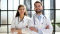 a female doctor and a male doctor are standing in the office with their arms crossed Royalty Free Stock Photo