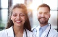 a female doctor and a male doctor are standing in the office with their arms crossed Royalty Free Stock Photo