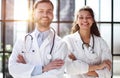 a female doctor and a male doctor are standing in the office with their arms crossed Royalty Free Stock Photo