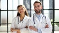 a female doctor and a male doctor are standing in the office with their arms crossed Royalty Free Stock Photo