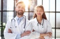 a female doctor and a male doctor are standing in the office with their arms crossed Royalty Free Stock Photo