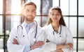 a female doctor and a male doctor are standing in the office with their arms crossed Royalty Free Stock Photo