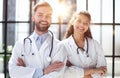 a female doctor and a male doctor are standing in the office with their arms crossed Royalty Free Stock Photo