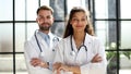 a female doctor and a male doctor are standing in the office with their arms crossed Royalty Free Stock Photo