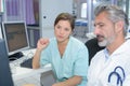 Female doctor with male nurse working at nurses station Royalty Free Stock Photo