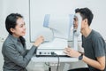 a female doctor and a male patient doing an eye check using a device Royalty Free Stock Photo