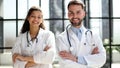 a female doctor and a male doctor are standing in the office with their arms crossed Royalty Free Stock Photo