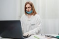 Female doctor with mask working on laptop telemedicine Royalty Free Stock Photo