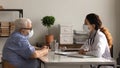 Female doctor and mature patient in facemasks consultation in hospital Royalty Free Stock Photo