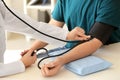 Female doctor measuring blood pressure of male patient in hospital Royalty Free Stock Photo