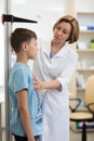 Female doctor measuring height of boy in clinic