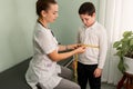 Female doctor measuring overweight boy in clinic. Childhood obesity