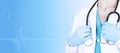 Female doctor in medical clothes with a stethoscope in her hands on a medical blue background. Side view. Healthcare banner. Copy Royalty Free Stock Photo
