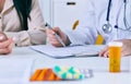 Female doctor meeting with a patient in the office, she is giving a prescription to the woman. Just hands over the table Royalty Free Stock Photo