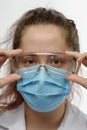 Female doctor, nurse or chemist wears protective mask and medical glasses Royalty Free Stock Photo