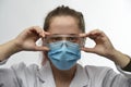 Female doctor, nurse or chemist wears protective mask and medical glasses Royalty Free Stock Photo