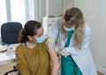 Female doctor or nurse giving shot or vaccine to a patient. Vaccination and prevention concept Royalty Free Stock Photo