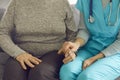 Female doctor or nurse holding the hand of her elderly patient as a sign of care and support. Royalty Free Stock Photo
