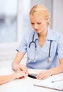 Female doctor or nurse measuring blood sugar value Royalty Free Stock Photo