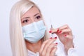 Female doctor or nurse in medical mask holding syringe with injection Royalty Free Stock Photo