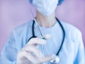 Female doctor or nurse in medical mask and in protective gloves holds a syringe with injection in hands. Coronavirus vaccination. Royalty Free Stock Photo