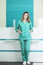 Female doctor or nurse in medical uniform looking straight. A hospital reception