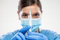 Female doctor or nurse wearing protective gloves holding vaccine syringe with needle Royalty Free Stock Photo