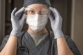 Smart Female Doctor or Nurse Wearing Scrubs, Protective Face Mask and Goggles Royalty Free Stock Photo