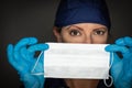 Female Doctor or Nurse Wearing Surgical Gloves Holding Up Medical Face Mask Royalty Free Stock Photo