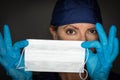 Female Doctor or Nurse Wearing Surgical Gloves Holding Up Medical Face Mask Royalty Free Stock Photo