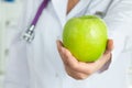 Female doctor offering green apple Royalty Free Stock Photo