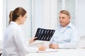 Female doctor with old man looking at x-ray Royalty Free Stock Photo