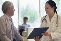 Female doctor and patient sitting down and discussing medical record in the hospital