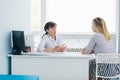 Female doctor and patient talking in hospital office. Health care and client service in medicine Royalty Free Stock Photo