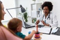 Female doctor pediatrician with baby patient and mother Royalty Free Stock Photo