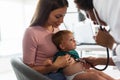 Female doctor pediatrician with baby patient and mother Royalty Free Stock Photo