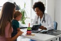 Female doctor pediatrician with baby patient and mother Royalty Free Stock Photo