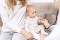 Female doctor pediatrician examining smiling baby girl with stethoscope doing a month checkup, checks heart and lungs Royalty Free Stock Photo