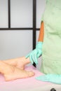 A female doctor podiatrist with gloves examines the female foot in the hospital.