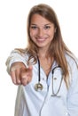 Female doctor pointing at camera Royalty Free Stock Photo