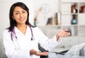 Female doctor politely inviting patient to medical office Royalty Free Stock Photo