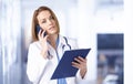 Female doctor portrait while talking with somebody on her mobile phone in the medical center Royalty Free Stock Photo