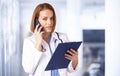 Female doctor portrait while talking with somebody on her mobile phone in the medical center Royalty Free Stock Photo