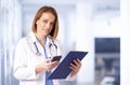 Female doctor portrait while talking with somebody on her mobile phone in the medical center Royalty Free Stock Photo