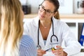 Female doctor prescribing medication for patient.