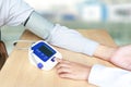 Female doctor press start button on blood pressure or sphygmomanometer - health concept.