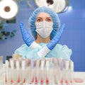 Portrait of doctor in scrubs. A female doctor in a protective cap and face mask in safety measures against the coronavirus