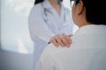 Female doctor put hand on patient shoulder for encouragement and discussion. Doctor and patient Royalty Free Stock Photo