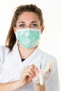 Female doctor puts on gloves plastic wearing protective face mask against coronavirus covid-19