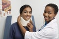 Female Doctor Putting Brace On Patient's Neck